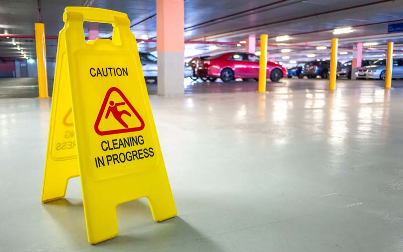 Warning janitorial sign of cleaning in progress in car park to warn passersby for safety